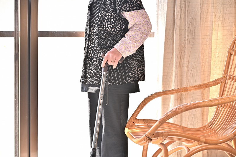 シニア女性が杖を持って立っている写真