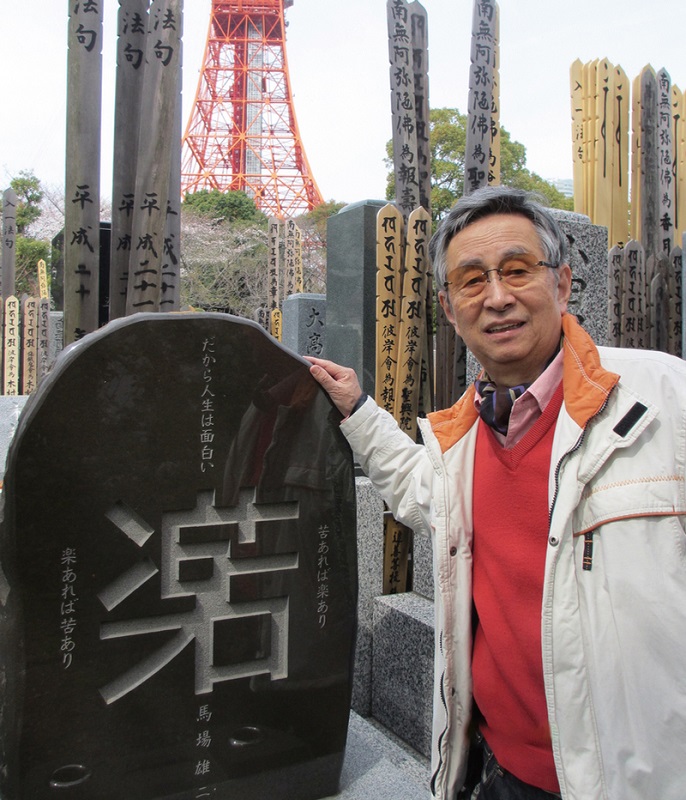  「楽」と「苦」のデザイン文字を刻んだ自らの墓石。後ろには大好きな東京タワーを臨む。