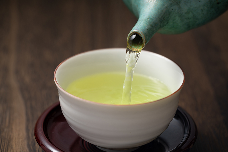 湯呑に緑茶を注いでいる写真