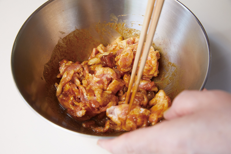 調味料を豚肉にまとわせて炊飯器に入れる