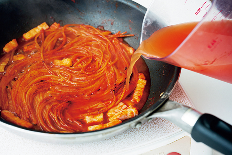 焼きつけた麺にペーストを伸ばした“トマトだし”を少しずつ加えて、じわじわと火を通す