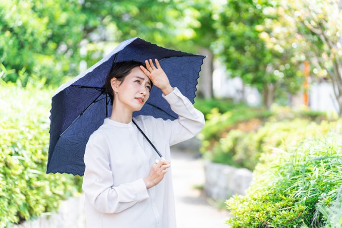 紺色の日傘をさす女性