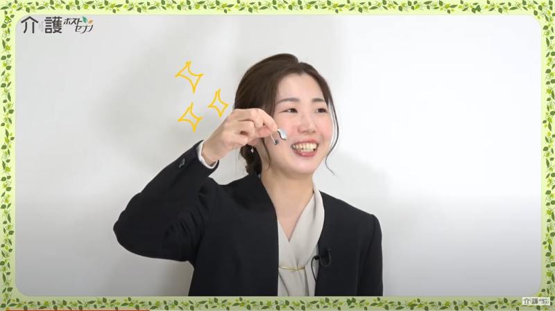 田中智子さんが補聴器を見せる写真