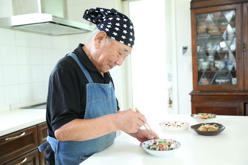 丁寧に盛り付けをする小林まさるさん人