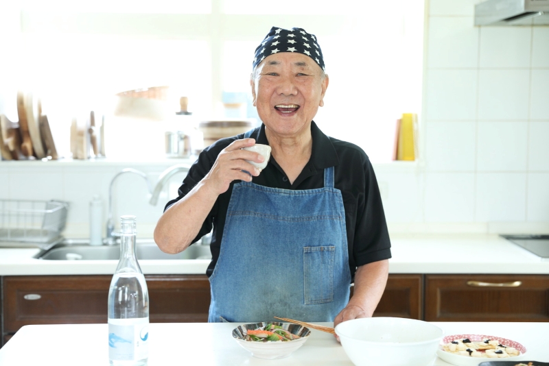 酒を片手に笑顔の小林まさるさん