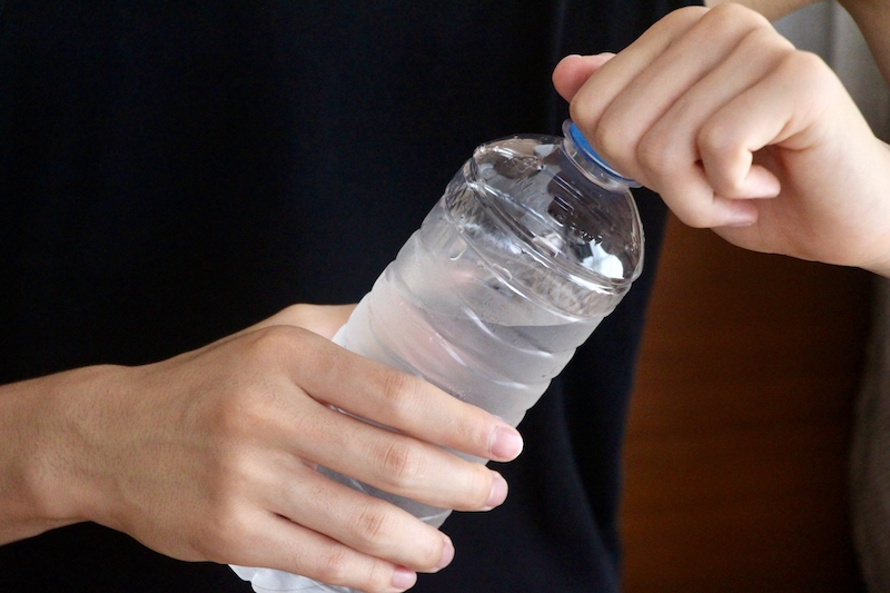 ペットボトルのふたを開けている