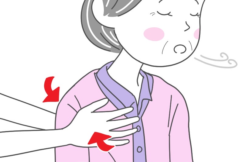 むせている女性の肺を、前後から押さえている