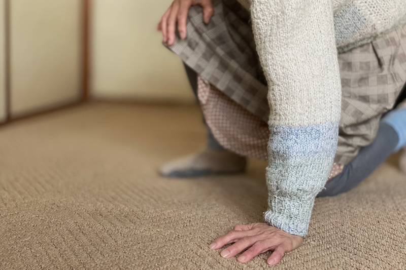カーペットの床に手をつく女性
