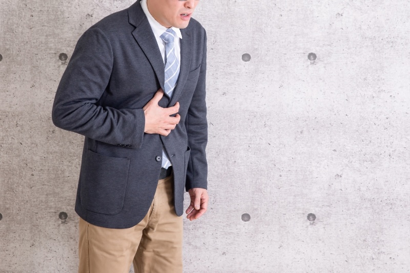 胃を押さえる男性