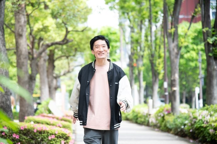 並木通りを歩く男性