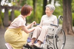 車いすに座った女性とエプロンをつけた女性