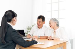 スーツ姿の女性と話すシニア