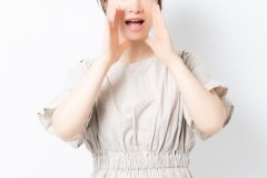 口元に手を当てている